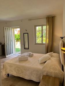 a bedroom with a large bed with two towels on it at B&B La Pintadera in Santa Teresa Gallura