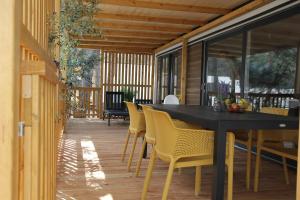 comedor con mesa negra y sillas amarillas en Mobile Home Bubamara, en Drage