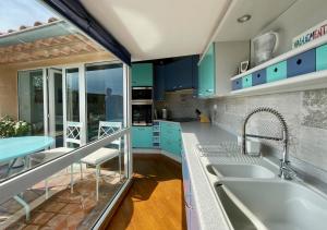 a kitchen with blue cabinets and a sink at L'Atypique - grande terrasse, calme, centre ville in Avignon