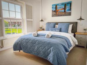 Un dormitorio con una cama azul con toallas. en Beach Boutique, en Camber