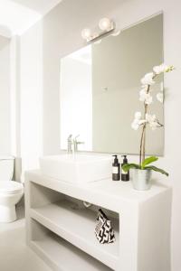 een witte badkamer met een wastafel en een spiegel bij Seaside Paros Ampelas in Ambelas