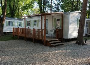 biały domek z werandą i schodami w obiekcie Mobil Home proche EUROPA PARK/RULANTICA w mieście Boofzheim