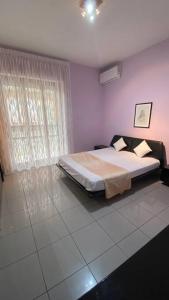 a bedroom with a bed and a large window at Casa vacanze “Villa Paola” in Pescara