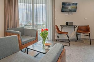 ein Wohnzimmer mit einem Sofa und einem Tisch mit Blumen in der Unterkunft Lubminer Meerblick Apartments in Lubmin