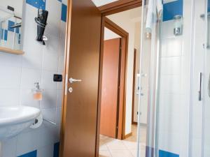 baño con puerta de ducha y lavamanos en BIKE HOUSE "beach", en Seriate 9 fotos más