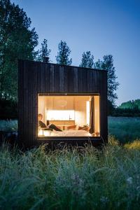 uma pequena casa preta com uma janela num campo em Slow Cabins Kinvara em Kinvara