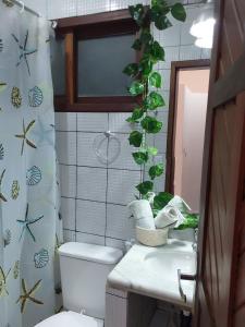 a bathroom with a toilet and a plant on the wall at Flat ideal no centro de pipa! in Pipa