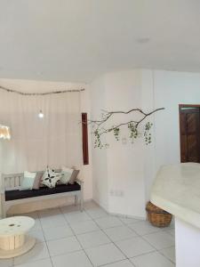 a living room with a couch and a tree branch on the wall at Flat ideal no centro de pipa! in Pipa