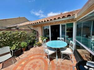 a patio with a blue table and chairs at L'Atypique - grande terrasse, calme, centre ville in Avignon +30 photos