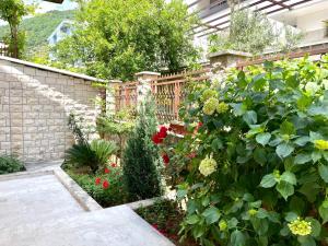 een tuin met bloemen en een houten hek bij Apartments Villa Mirjana in Budva