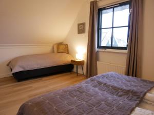 a bedroom with two beds and a window at Villa Buiten 108 in Callantsoog