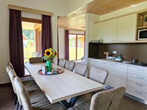 a kitchen with a table and chairs and a kitchen with a table and a counter at Apartment HORTENZIJA near Terme Topolšica in Topolšica