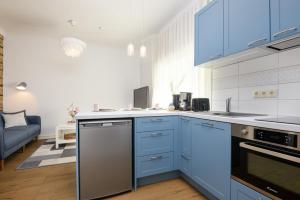 a kitchen with blue cabinets and a stove top oven at Aiaviisa apartment in Pärnu