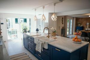 a kitchen with blue cabinets and a sink in it at Flowers & Faces Guesthouse in Ponte de Lima