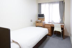 a bedroom with a bed and a desk with a computer at Toyokawa Grand Hotel in Toyokawa +28 photos