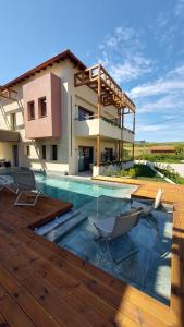 a house with a swimming pool in front of a house at Kynara Elegant Living in Ierissos