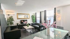 - un salon avec deux canapés et une table en verre dans l'établissement The Amsterdam Hotel Apartment in the Center, à Amsterdam