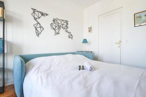 - une chambre dotée d'un lit blanc avec deux bougies dans l'établissement Charming 1br at the doors of Paris - Welkeys, à Issy-les-Moulineaux