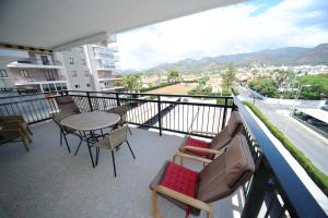 einen Balkon mit einem Tisch und Stühlen sowie Stadtblick in der Unterkunft LOS DELFINES 6 pax Orange Costa in Benicàssim