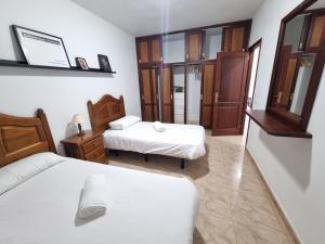 um quarto com 2 camas e um espelho em VV Mirador Isla Bonita "by henrypole home" em Mazo