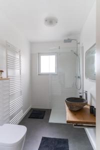 ein Bad mit einer Badewanne, einem Waschbecken und einer Dusche in der Unterkunft Ferienwohnung Gartenkamp Celle in Celle