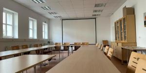 an empty classroom with wooden tables and chairs at Ferienappartements inTOuR in Ockfen