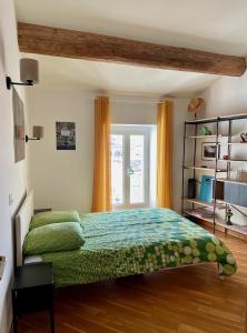 a bedroom with a green bed and a window at L'Atypique - grande terrasse, calme, centre ville in Avignon