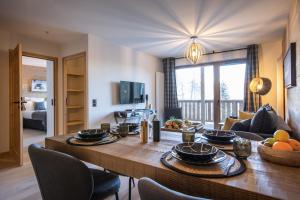 een woonkamer met een grote houten tafel met stoelen bij TERRESENS - Le Snoroc in Aime La Plagne