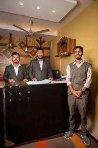 a group of three men standing in front of a desk at GS RESIDENCY in Guwahati