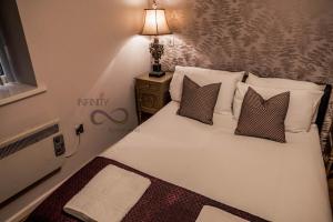a bedroom with a white bed with pillows and a lamp at Contractor Bookers At Infinity Apartments in Liverpool