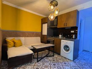een woonkamer met een bank en een wasmachine bij Beta GuestHouse in Antalya