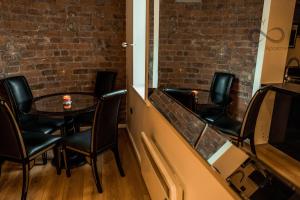a table and chairs in a room with a brick wall at Contractor Bookers At Infinity Apartments in Liverpool