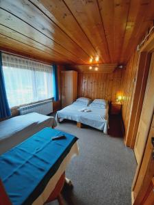 a bedroom with two beds in a wooden cabin at Kwatery u Malika-blisko do basenów Termalnych in Biały Dunajec