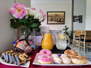 a table topped with a plate of donuts and orange juice at GRAND HARRACHOV PENSION v centru in Harrachov