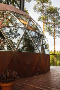 a glass dome building with trees in the background at Treehouse dome in Vidnes