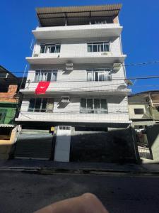 a tall white building with a red sign on it at THE BROTHERS in Angra dos Reis