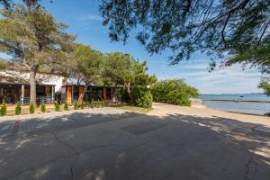 eine leere Straße vor einem Haus am Wasser in der Unterkunft Guest House Malenica in Sukošan