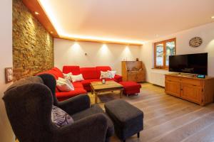 a living room with a red couch and a tv at Haus Schönblick in Ruhpolding