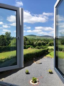 a sliding glass door with a view of a yard at B&B and Cottage Rental "Mon Petit Cottage" in Bunclody