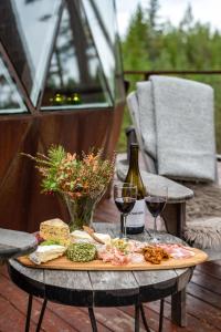 a table with a plate of food and two glasses of wine at Treehouse dome in Vidnes