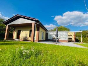 a house with a green lawn and an umbrella at Ferienoase Eisvogel in Malchin