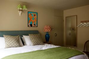 Schlafzimmer mit einem Bett mit einem grünen Kopfteil in der Unterkunft The Queen's Head in Broad Chalke
