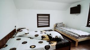 ビストリツァにあるCasa de vacanta Natyのベッドルーム1室(ベッド2台、ソファ付)