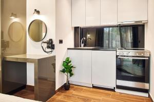 a kitchen with white cabinets and a sink and a stove at Amuse Luxury Apartments in Zakynthos +17 photos
