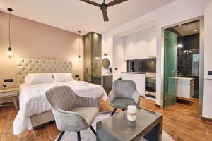 a bedroom with a bed and two chairs and a table at Amuse Luxury Apartments in Zakynthos