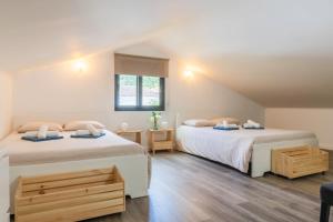 a bedroom with two beds and a window at Encanto Village House in Faial da Terra
