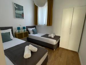 two beds in a small room with two towels at Mediterra 1 in Crikvenica