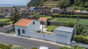 a white house on the side of a street at Encanto Village House in Faial da Terra