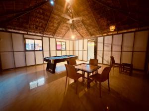 a large room with a ping pong table and chairs at Lake N River Resort Munroe Island in Munroe Island