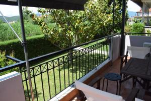 einen Balkon mit einem schwarzen Zaun sowie einem Tisch und Stühlen in der Unterkunft Nakis Apartment All Seasons in Stavros